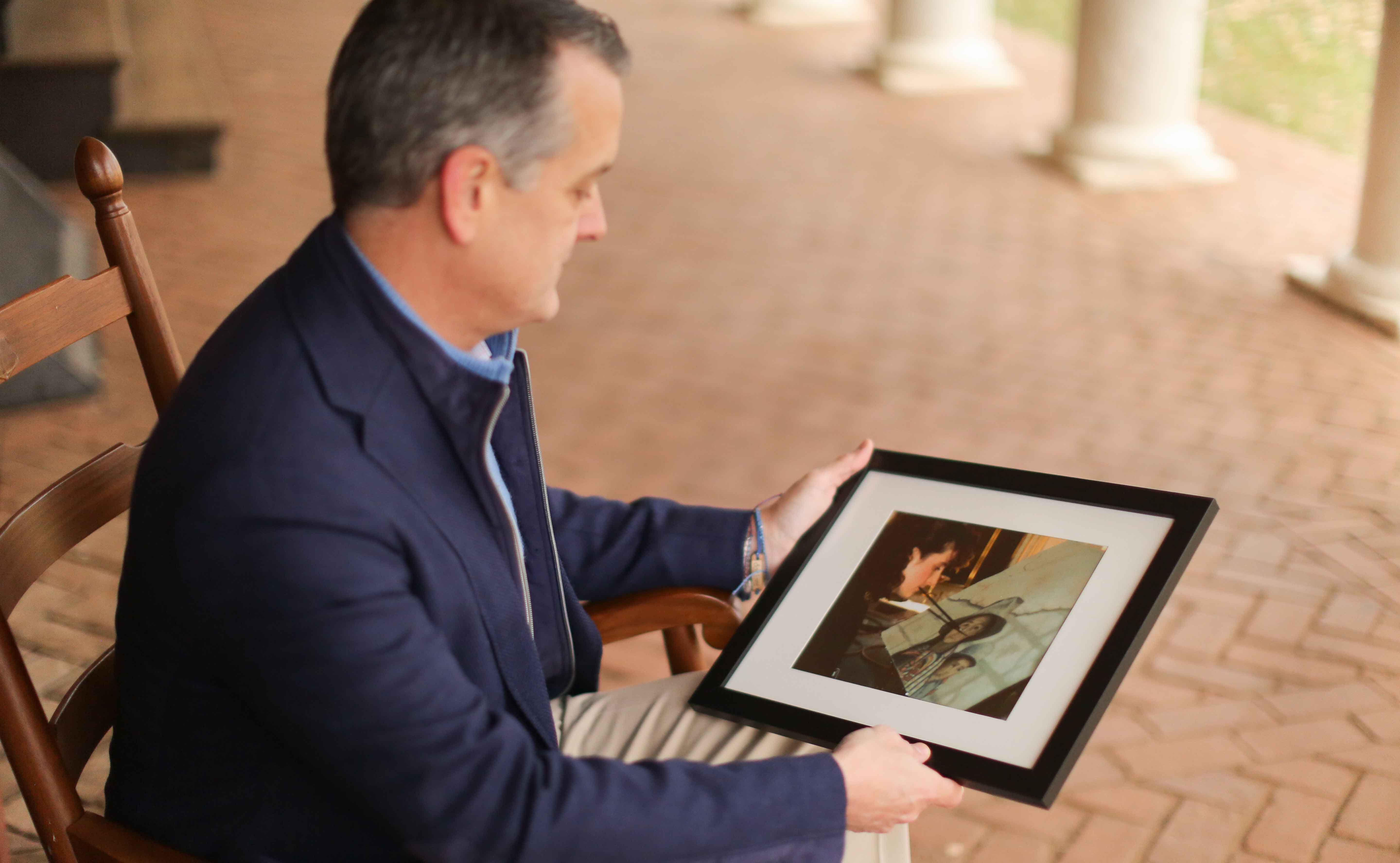 Clint Heiden holding a photo of his sister painting