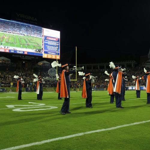 Marching band on field with jumbotron in background